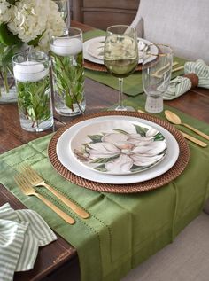 a table set with plates, silverware and flowers