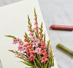 some pink flowers are in a vase and two crayons