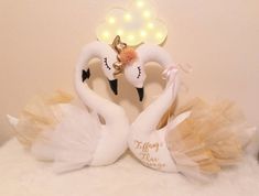 two white swans in tutus with lights on their heads and the words happy new year