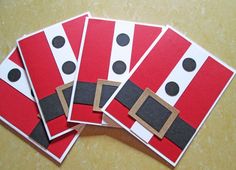 four red and black christmas cards with santa claus's suit on them, sitting next to each other