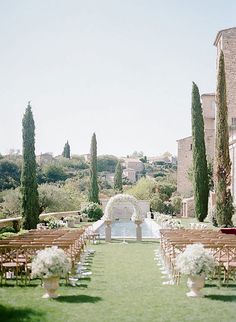 an outdoor ceremony set up with chairs and flowers