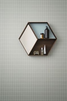 a shelf that has some items on it and is hanging from the wall in front of a tiled wall