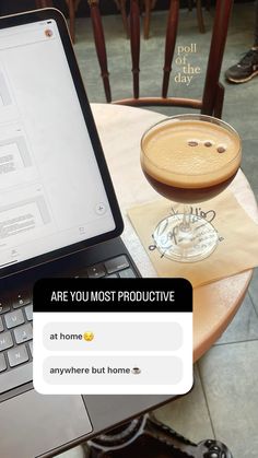 an open laptop computer sitting on top of a wooden table next to a cup of coffee