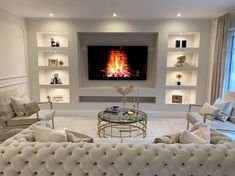 a living room filled with furniture and a flat screen tv mounted to the wall over a fire place