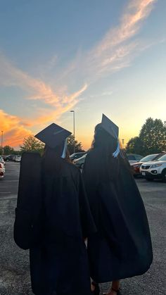 two graduates walking towards the parking lot at sunset