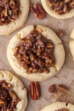 several pecan cookies are arranged on a baking sheet with pecans in the middle