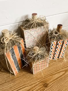 three small boxes with twine tied to them sitting on a wooden floor next to a wall