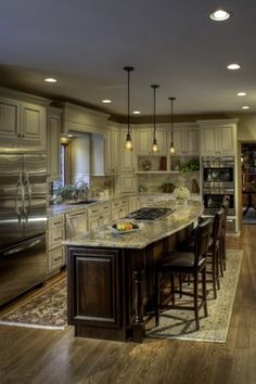 a large kitchen with an island in the middle and lots of counter space on one side