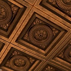 an intricately designed ceiling in a room with gold and black tiles on the ceiling