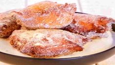 powdered sugar donuts in a bowl on a table