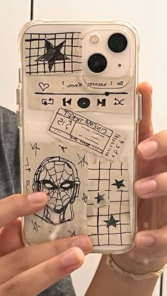 someone holding up their phone case with drawings on it