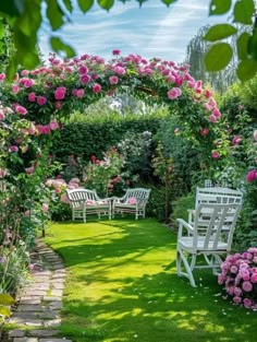 a garden with white chairs and pink flowers on the grass, surrounded by greenery