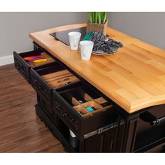 a kitchen island with two drawers on it and coffee cups in the bottom drawer next to it