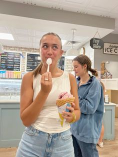 a woman eating an ice cream cone in a store with two other women standing behind her