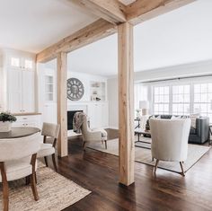 a living room filled with furniture and a clock mounted to the side of a wall