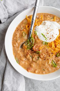 a bowl of white bean chili with sour cream on top