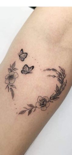 a woman's arm with flowers and butterflies on the left side of her body