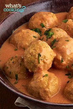 meatballs with sauce and parsley in a bowl