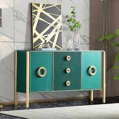 a green cabinet with gold handles and knobs in a room next to a potted plant