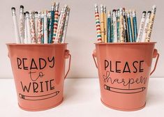 two buckets filled with pens and writing utensils