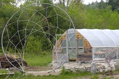 a small building with a large circular metal object in the foreground and another structure behind it