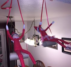 two elfs hanging upside down from the ceiling