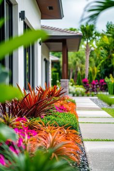 an outdoor garden with colorful flowers and plants in the foreground, next to a house