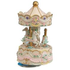 a white and gold carousel with pink flowers on it's top, sitting in front of a white background