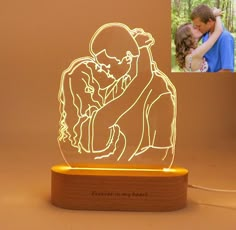 a couple kissing in the middle of a wooden stand with an image of them on it