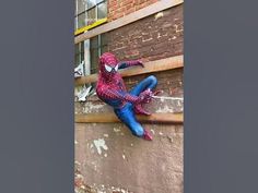 a spider man climbing up the side of a building