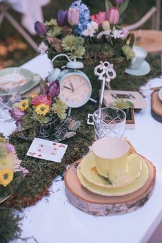 a table topped with plates and cups filled with flowers