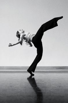 a man and woman are dancing in the middle of an empty dancefloor with their arms outstretched