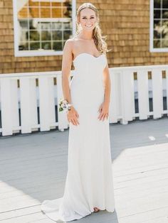 a woman in a white dress standing on a porch