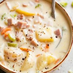 a bowl of soup with ham, potatoes and carrots