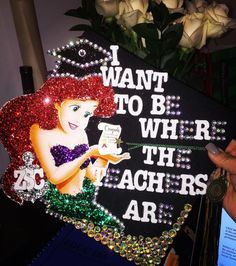 a woman is holding up a sign with the words i want to be where the teachers are