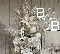 a christmas tree decorated with silver, white and brown ornaments is displayed in front of a wooden wall