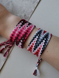 a woman's arm with two bracelets on it and one has a tassel