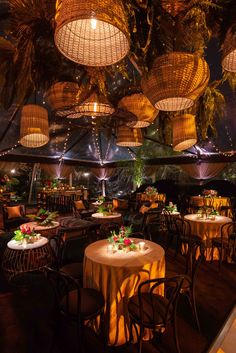 an indoor dining area with round tables and wicker lamps