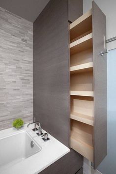 a bathroom with a sink, bathtub and shelving unit in the middle of it