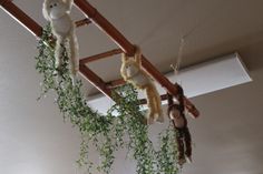 several stuffed animals hanging from a wooden ladder