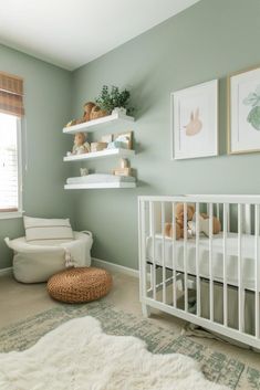 a baby's room with green walls and white furniture