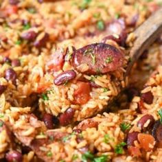 a close up of rice and beans with a wooden spoon