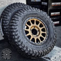 an off - road tire on the ground next to some tires