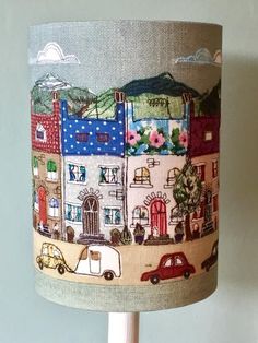 a lampshade with an image of a town on it and a car driving down the street