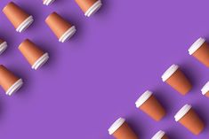 several coffee cups are lined up in the shape of an arrow on a purple background