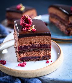 a piece of chocolate cake on a plate with raspberries in the middle and one slice missing