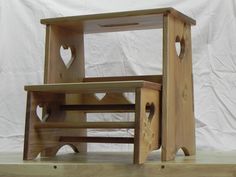 two wooden stools sitting on top of each other in front of a white backdrop