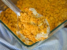 a spoon with some food in it on top of a blue and white checkered cloth