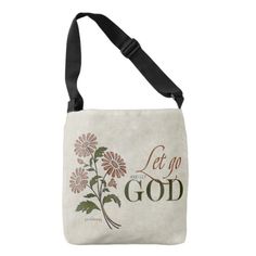 a cross body bag with flowers on the front and let no god written in it