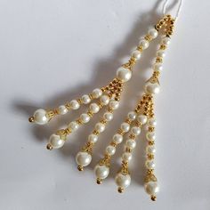 Handmade tassels, made to make your outfits stand out!!  Ideal to be sown into sarees, lehengas, or salwars or any asian outfits. Please handle with care. This item is delicate and possible to damage if not sown in properly. No returns, refunds or exchanges. Sold as seen. If you require any personalised tassels (colour, length etc) in this design, please contact me. White Tikka With Latkans For Navratri, White Dupatta With Latkans For Eid, Eid Celebration Tikka With Latkans, Elegant Dupatta With Latkans For Celebration, Elegant Celebration Dupatta With Latkans, White Dupatta With Latkans For Navratri, Traditional Gold Pearl Earrings With Latkans, Gold Long Drop Jewelry With Latkans, Gold Bollywood Danglers With Latkans